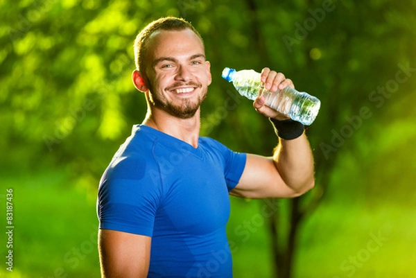 Obraz Athletic mature man drinking water from a bottle