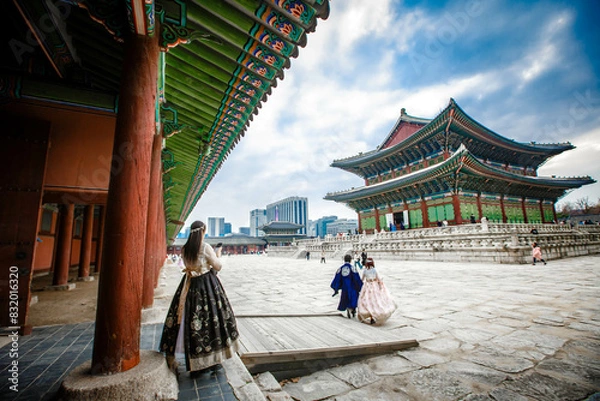 Obraz Tourists in national clothes walk in Gyeongbokgung Palace