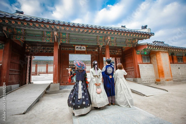 Obraz Tourists in national clothes walk in Gyeongbokgung Palace