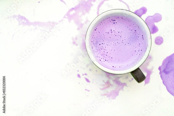 Fototapeta Top View of a Cup with Purple Latte on White Background with Spilled Drink