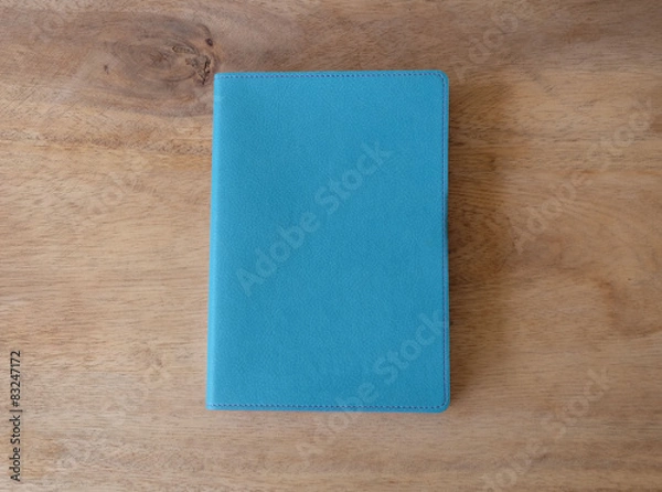 Obraz Sky blue leather notebook on wooden table, the personal organize