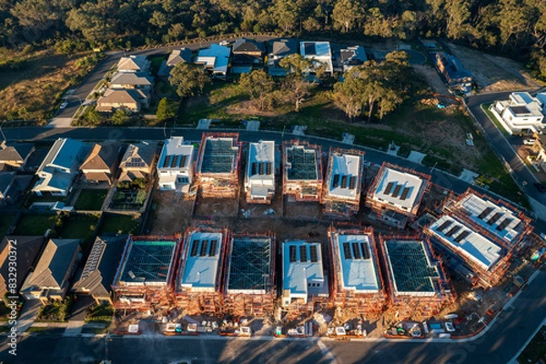 Obraz Late afternoon aerial view of modern houses with solar panels and scaffolding under construction in the outer suburbs of Sydney, Australia.