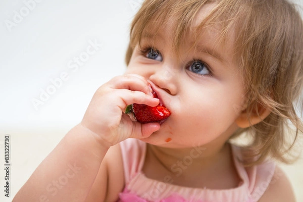 Obraz Portrait of a beautiful little girl with strawberry