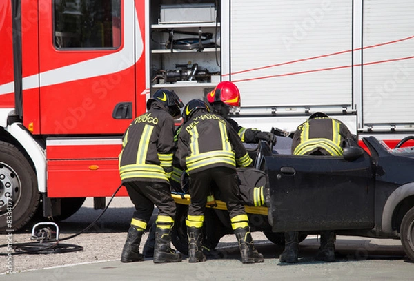 Fototapeta Firefighters pull in wounded by car plates after road crash