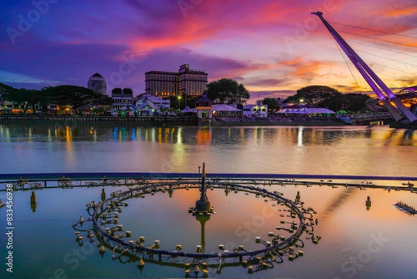 Fototapeta view of the river and fountain equipment and bridge at dusk