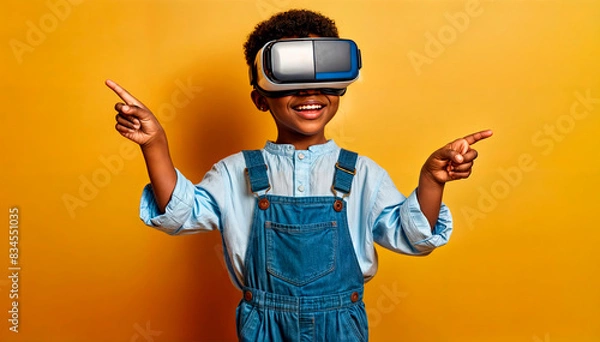 Fototapeta Child in virtual reality headset pointing, against an orange background. Technology and education concept. Ideal for tech businesses, educational content, and marketing. Copy space available.