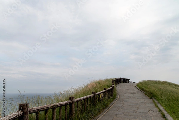 Fototapeta View of the walkway at the seaside on a cloudy day