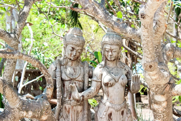 Fototapeta Ancient Stone Statues in Serene Nature, Illuminated by Sunlight in Forest Setting