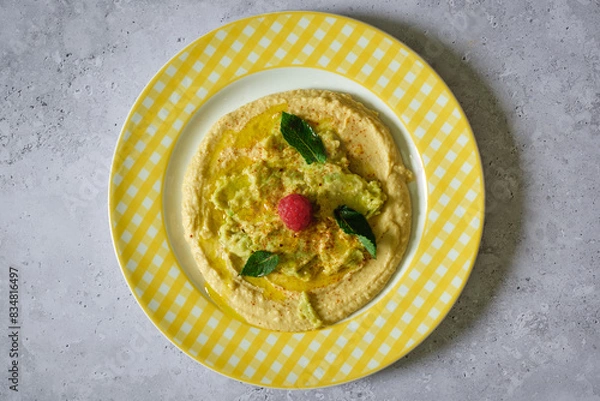 Obraz Minimalist zenithal view of a plate with hummus, avocado and mint.