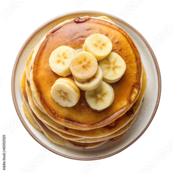 Fototapeta A close up image of a stack of golden brown pancakes topped with fresh banana slices