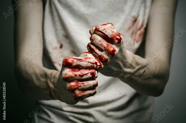 Fototapeta murderer shows bloody hands and experiencing depression and pain