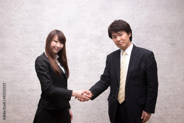 Obraz オフィスで握手するビジネスマンとビジネスウーマン