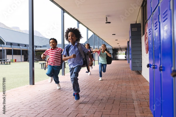 Fototapeta In school, diverse group of young students running in hallway outdoors, copy space