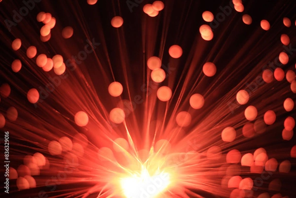 Fototapeta Mystical red and black background with a light source from below, diverging rays and lights at the ends