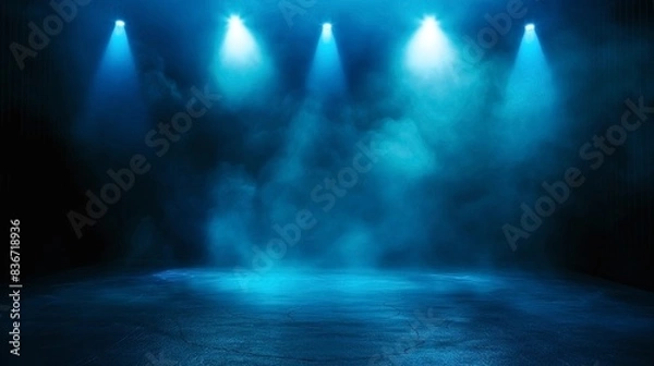 Fototapeta Empty stage with four blue spotlights and smoke, creating a dramatic and atmospheric ambiance.