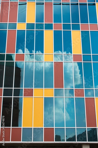 Fototapeta clouds floating in the sky reflected in the glass of skyscraper