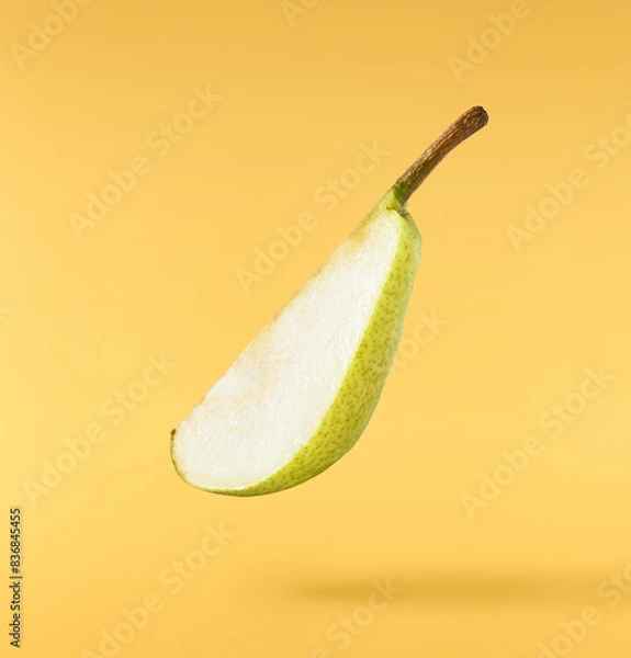 Fototapeta Fresh ripe Pear falling in the air, isolated on yellow background. Food levitation or zero gravity concept. High resolution image