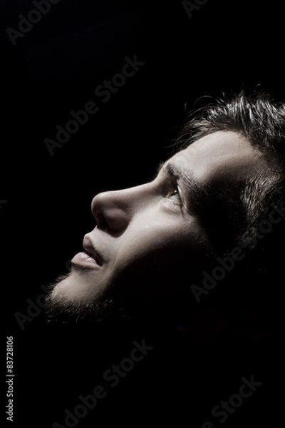Obraz Man side profile portrait looking up lighted on a half face