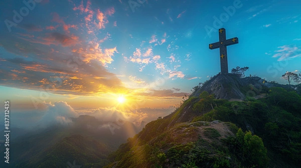 Fototapeta A Christian cross atop a high mountain, with the early morning mist rising around it and the first golden rays of the sun breaking through, highlighting the cross against a vibrant blue sky.