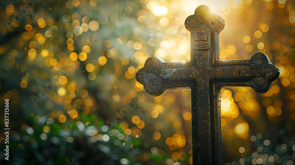 Obraz A Christian cross at the entrance to a forest, with the late afternoon sunlight streaming through the trees and creating a golden bokeh that seems to welcome visitors into a sacred space.
