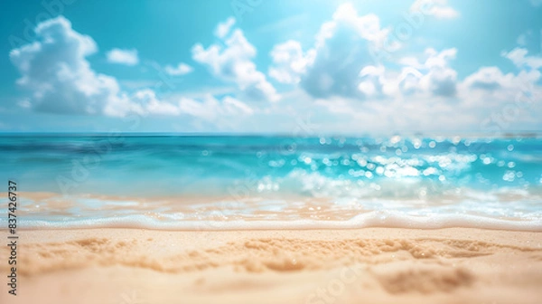 Fototapeta Abstract blur defocused background featuring sun rays on a tropical summer beach. Beach with golden sand, ocean, and a blue sky with white clouds in it