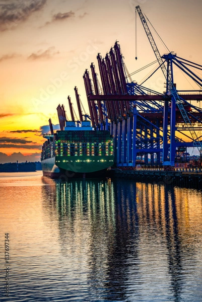 Obraz Containerschiff an einem Containerterminal in Hamburg während des Sonnenuntergangs, vertikal