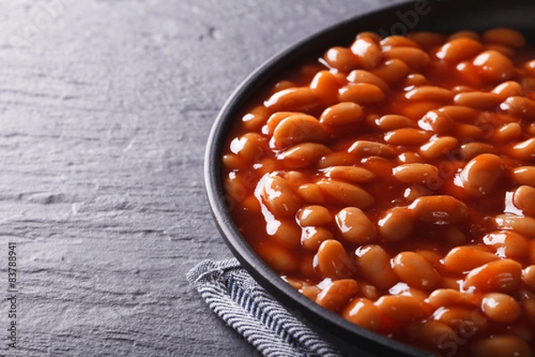 Obraz beans in tomato sauce in a black bowl 