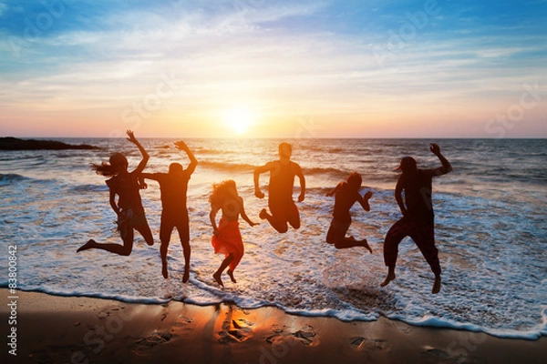 Obraz Six people jumping on beach at sunset.