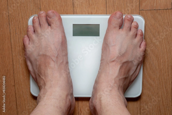 Obraz A person measuring weight on a scale