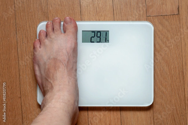 Fototapeta A person measuring weight on a scale
