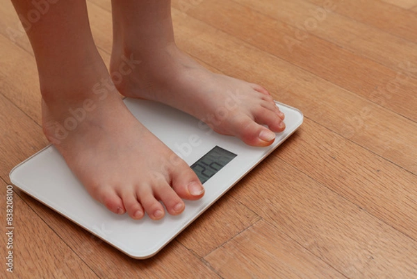 Fototapeta A person measuring weight on a scale