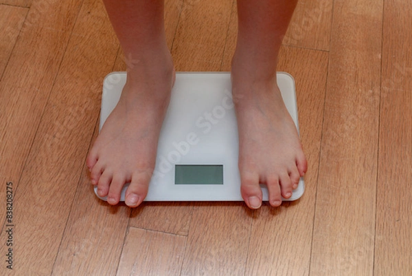 Fototapeta A person measuring weight on a scale