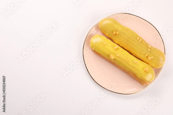 Fototapeta Delicious eclairs covered with glaze on white background, top view
