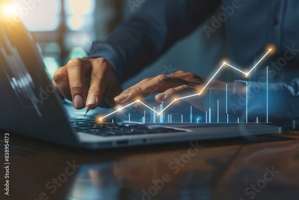 Fototapeta Investment strategy planning. Businessperson hands use a laptop with arrows graphically displayed on an upward growth screen, analyzing financial growth charts, and business planning.