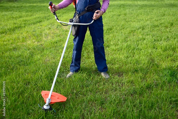 Fototapeta Man mows a grass