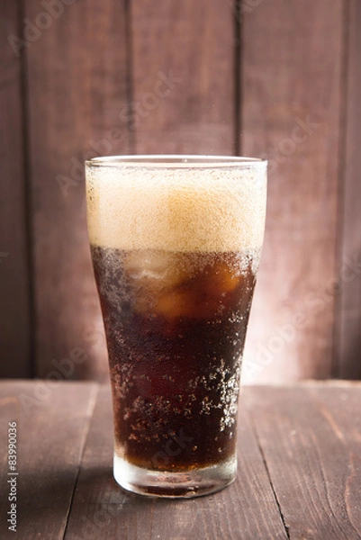 Obraz Cola in glass with ice on wooden background
