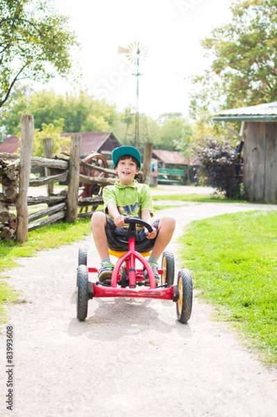 Obraz happy boy on a peddle go-cart having fun