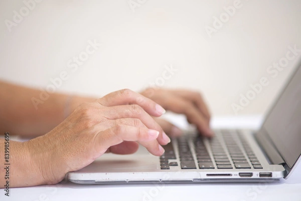 Fototapeta Closeup shot of female hands working on computer keyboard