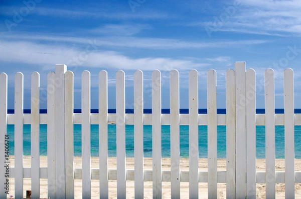 Obraz white fence on the beach with blue sea