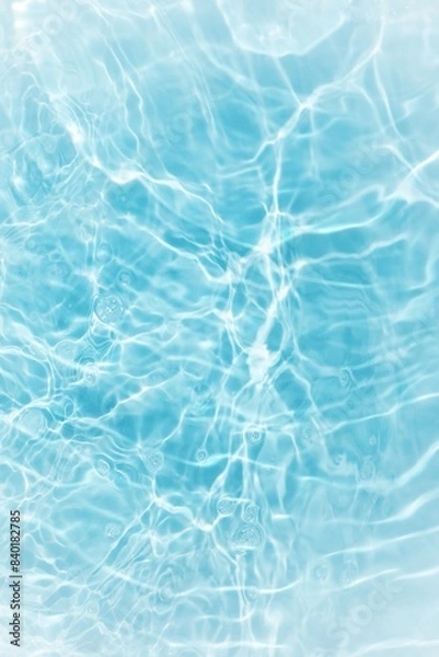 Fototapeta Blue water with ripples on the surface. Defocus blurred transparent blue colored clear calm water surface texture with splashes and bubbles. Water waves with shining pattern texture background.	