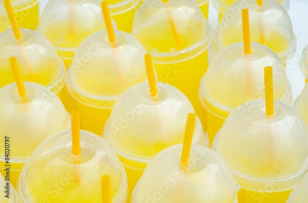 Fototapeta Yellow lemonade plastic cups