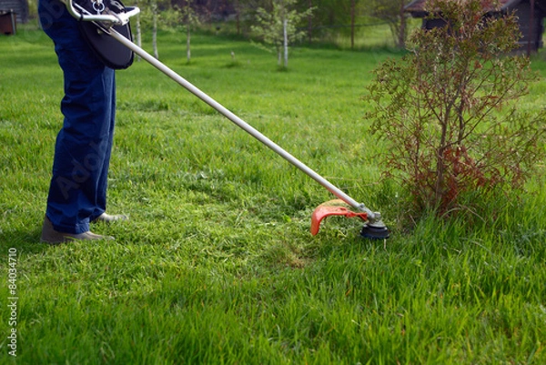 Fototapeta Man mows a grass