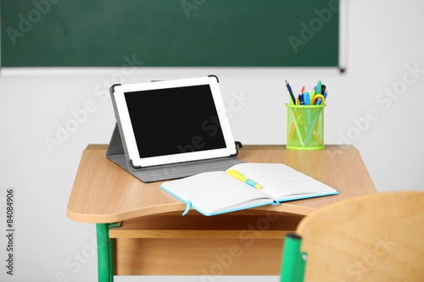 Fototapeta Wooden desk with stationery and tablet in class 