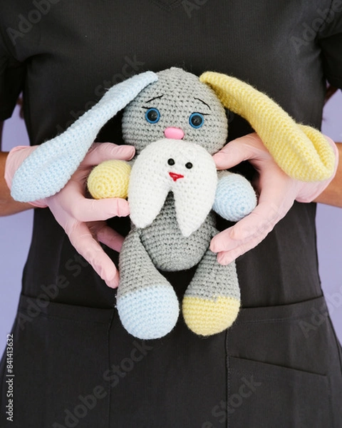 Fototapeta female dentist doctor holds a toy in the form of a hare in her hands. young doctor dentist with a toy in his hands. dentist concept