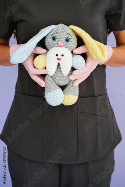Fototapeta female dentist doctor holds a toy in the form of a hare in her hands. young doctor dentist with a toy in his hands. dentist concept