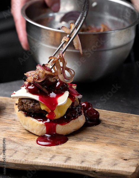 Fototapeta Preparation of burger. Professional chef is preparing burger. Burger making. Cooking hamburger concept.