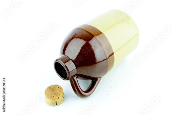 Fototapeta Old clay jug with a cork used to hold booze, with a filled glass next to it.