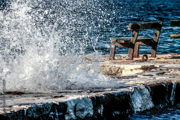 Fototapeta Waves crashing against a rock on the coast.