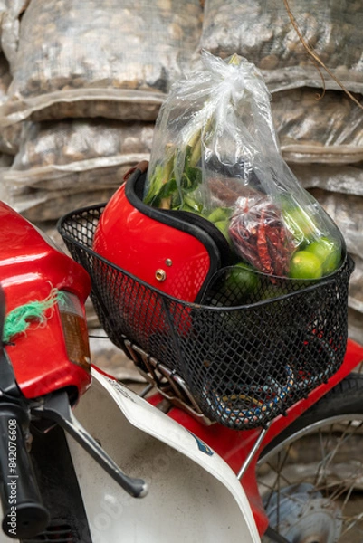 Fototapeta A motor bike red helmet baskets  a bag of green lemons and chilis
