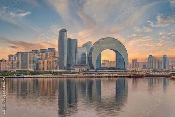 Obraz The Crescent Development Project features distinct modern architecture, including the Crescent Hotel, set against a beautiful sunset with reflections on the Caspian Sea in Baku, Azerbaijan